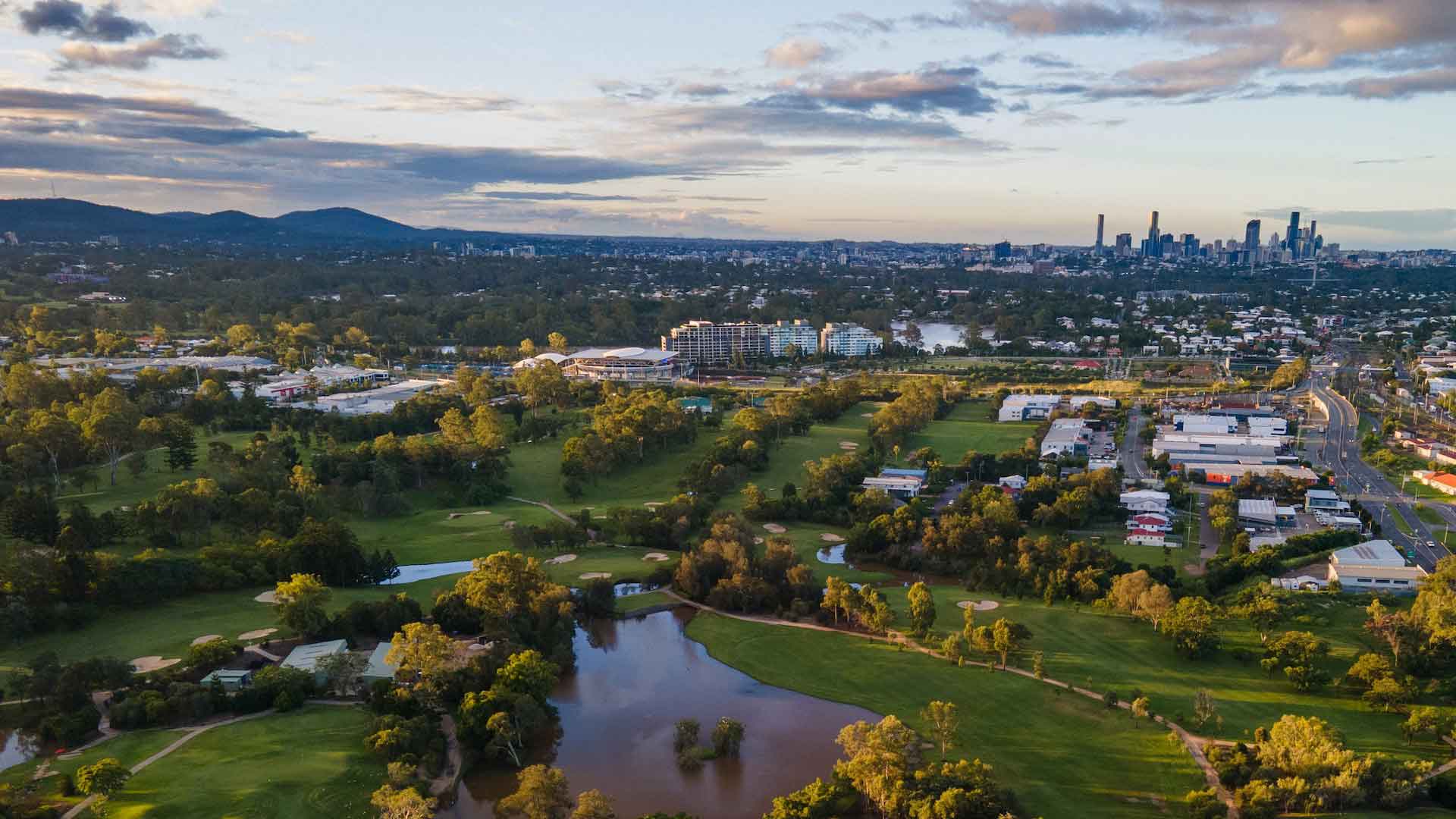 Aerial view of The Brisbane Golf Club with the city skyline behind